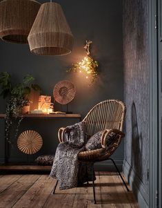 a wicker chair sitting on top of a hard wood floor next to a table