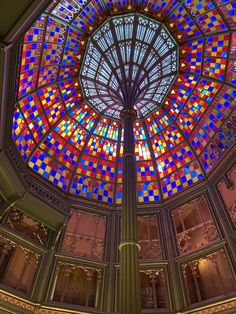 an ornate glass dome in the center of a building with stained glass windows and columns