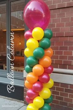 a bunch of balloons that are on the side of a building