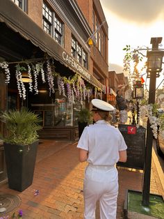 a woman in white uniform walking down the street