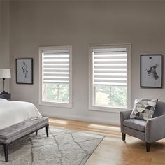 a bedroom with two windows and a bed in the corner, along with a chair