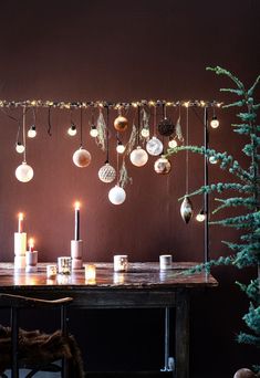 a table with candles and ornaments hanging from it