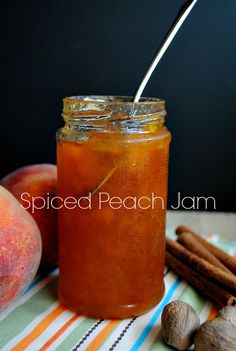 a glass jar filled with liquid next to some fruit and cinnamon on a striped table cloth