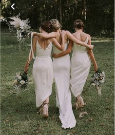 three bridesmaids walking in the grass with their backs to each other