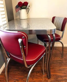 two red chairs and a white table in a room