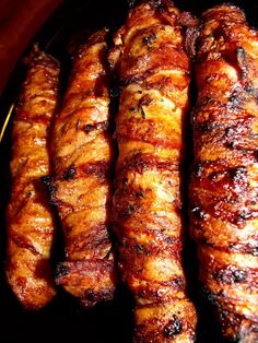 several skewers of meat sitting on top of a black plate