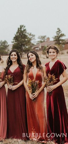 a group of women standing next to each other in long red dresses holding bouquets