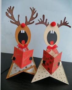 two paper reindeers are standing next to each other