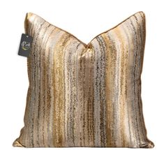 a gold and silver striped pillow on a white background