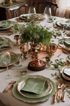 Elegant dining table set with green and gold dishes, copper accents, and a centerpiece of greenery. Chic Dining Table, Beautiful Dining Table, Table Scapes