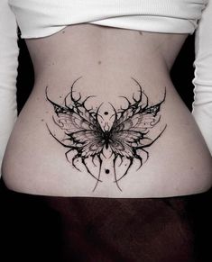 a woman's stomach with a butterfly tattoo on the side and an intricate design