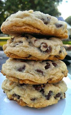 a stack of chocolate chip cookies sitting on top of a white plate