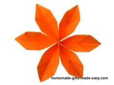 an orange origami flower on a white background