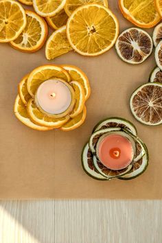 orange slices cut in half with a lit candle surrounded by other sliced citrus fruits on a table