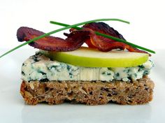 a sandwich with bacon, blue cheese and an apple