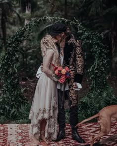 a man and woman dressed up as pirates kissing in front of a dog on a rug