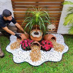 a man kneeling down next to a potted plant