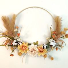 a wreath with flowers and feathers on it