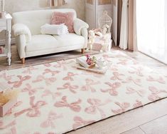 a living room with a white couch and pink rug on the floor in front of a window