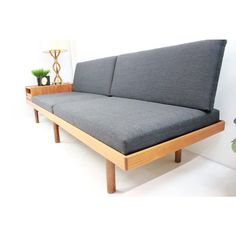 a couch sitting on top of a wooden table next to a potted green plant