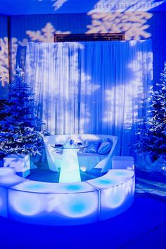 a living room decorated for christmas with blue lighting