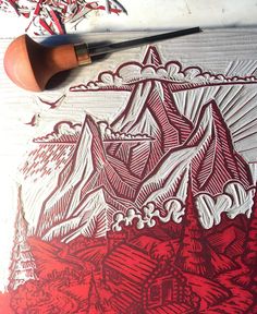 a red and white drawing on top of a piece of paper with a brush next to it