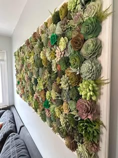 a large succulent wall mounted to the side of a white wall in a living room