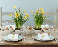 the table is set with eggs and daffodils