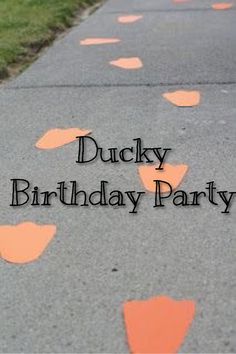 the words ducky birthday party are written in black on an orange painted street line