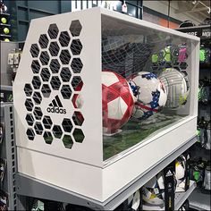 a display case with soccer balls inside of it