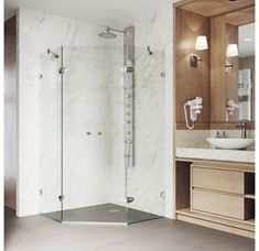 a bathroom with a sink, mirror and shower stall in the middle of the room