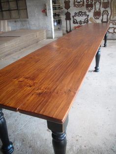 a long wooden table sitting inside of a building