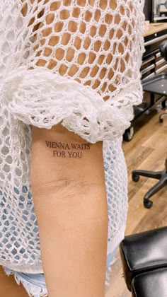 a woman's arm with the words vienna wait for you tattooed on her left arm