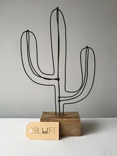 a metal cactus sitting on top of a wooden block