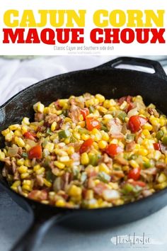 a skillet filled with corn and vegetables on top of a table