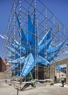 scaffolding is being erected around the large blue object