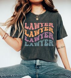 "Comfort Colors Lawyer T-shirt, Retro Lawyer Tee, Gift for Lawyer, Custom Lawyer Shirt, Tshirt for Lawyer, Womans Tee Shirt https://toptrendtshirtsus.etsy.com NOTE: Please contact me for more size,color, product (sweatshirt, hoodies,kids etc) options. I'm always here to help. Unisex Garment-Dyed T-shirt Comfort Colors® 1717 *Medium fabric (6.1 oz/yd² (206.8 g/m *Relaxed fit *Sewn-in twill label *100% ring-spun cotton About Comfort Colors introduces its garment-dyed t-shirt; a fully customizable tee made 100% with ring-spun cotton. The soft-washed, garment-dyed fabric brings extra coziness to your wardrobe while the relaxed fit makes it an excellent daily choice. The double-needle stitching throughout the tee makes it highly durable while the lack of side-seams helps the shirt retain its tu Multicolor Pre-shrunk Graphic Tee, Trendy Multicolor T-shirt With Text Print, Multicolor Graphic Tee T-shirt, Vintage Multicolor T-shirt With Letter Print, Funny Print Graphic Tee With Short Sleeves, Multicolor Graphic Tee Shirt, Graphic Tee With Funny Print And Crew Neck, Graphic Tee With Text Print And Crew Neck, Multicolor Relaxed Fit Pre-shrunk T-shirt