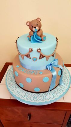 a blue and brown cake with a teddy bear on top