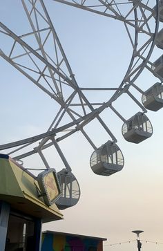 the ferris wheel is hanging upside down in front of a building with many lights on it