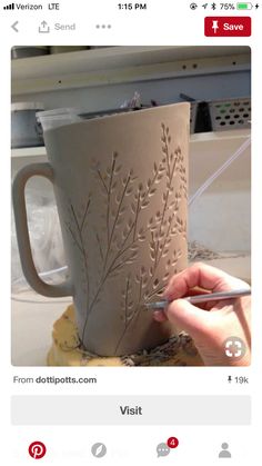 someone is painting a mug with leaves on it