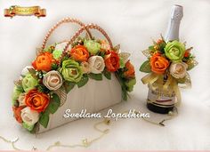 two white purses with flowers on them sitting next to a bottle of booze