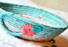 a close up of a basket on a table with beads and flowers in the background