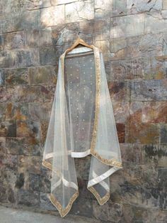 a dress hanging up against a stone wall