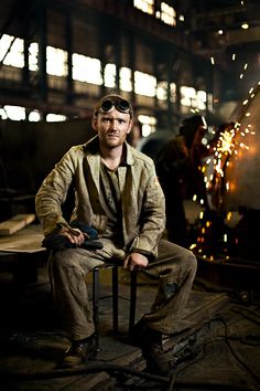 a man sitting on top of a chair in a warehouse