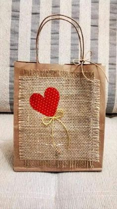 a brown bag with a red heart on it sitting on top of a white couch