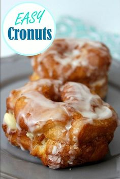 two glazed donuts sitting on top of a gray plate