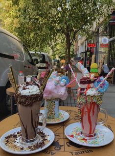 two drinks are sitting on the table with sprinkles and icecream