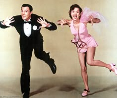 a man and woman dressed in pink posing for the camera with their arms spread out