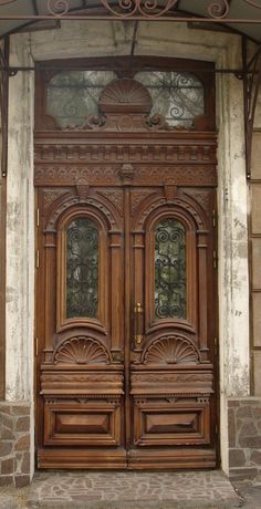 an old wooden door with ornate carvings on the front and side panels, in a stone building