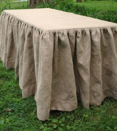 an image of a table cloth on the ground with grass in the foreground and trees in the background